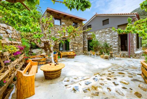 a patio with a tree and tables and chairs at Ellafos Traditional Living in Elafonisi