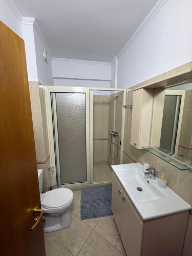a bathroom with a toilet and a shower and a sink at 12valentina in Vlorë