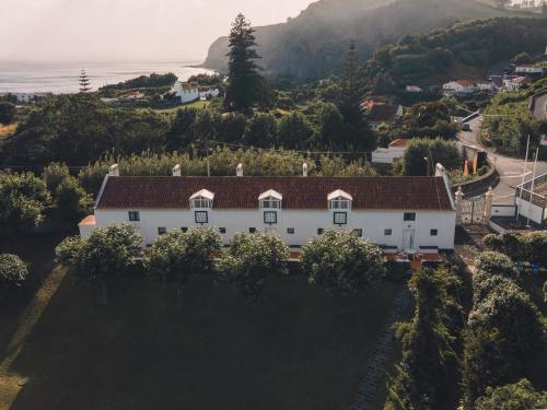 an aerial view of a white house on a hill at Apartamentos da Galé in Caloura