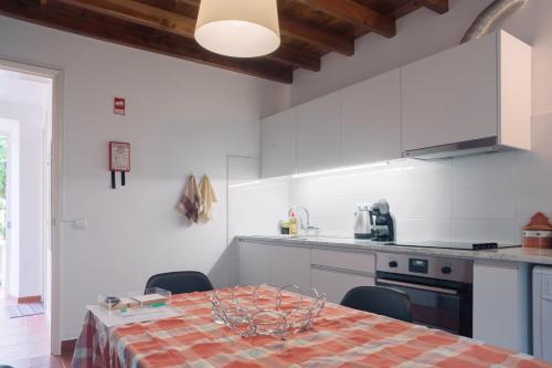 a kitchen with a table and chairs in a room at Apartamentos da Galé in Caloura