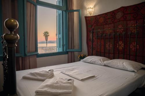a bedroom with a bed with two towels on it at Pension Nora in Chania
