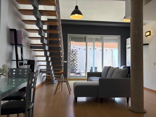 a living room with a couch and a staircase at Loft Almagro in Almagro