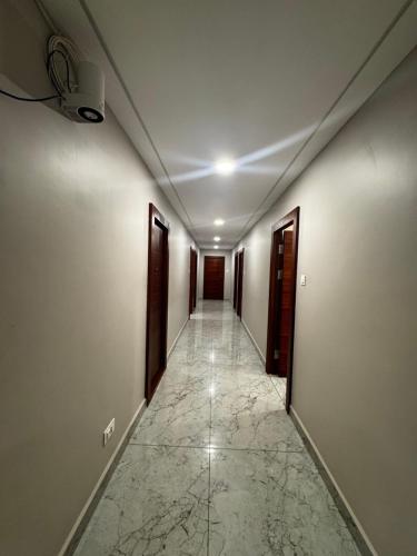 pasillo vacío con puertas y suelo de baldosa en Hotel SRI DEEPTHI LODGE, en Ādoni