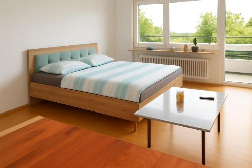 una camera da letto con un letto e un tavolo di Ferienwohnung Bella Vista a Eimeldingen