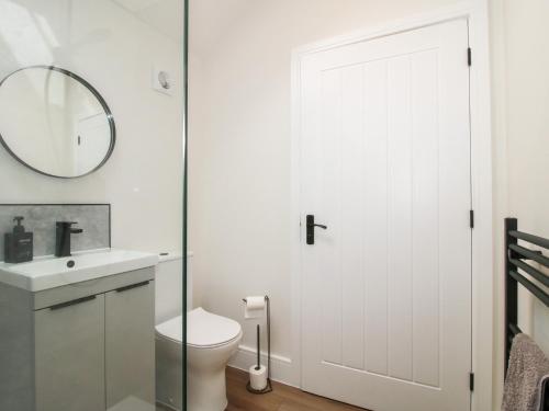 a bathroom with a white toilet and a mirror at Oak Barn in Shrewsbury