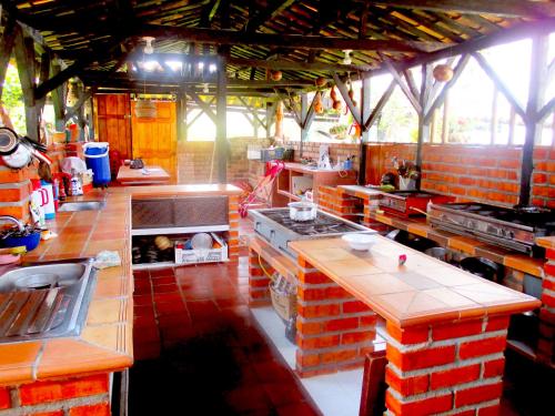 a large kitchen with red brick walls and counters at Hotel Alto de los Andaquies in San Agustín