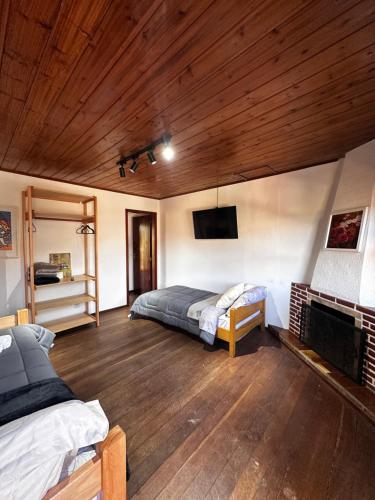 a bedroom with a bed and a tv on the wall at Villaggio Harmonia Monte Verde in Camanducaia