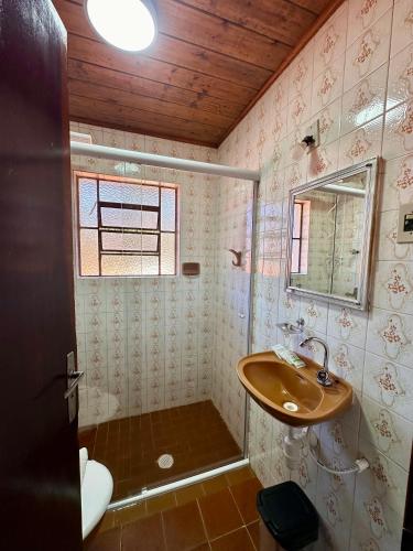 a bathroom with a sink and a mirror at Villaggio Harmonia Monte Verde in Camanducaia
