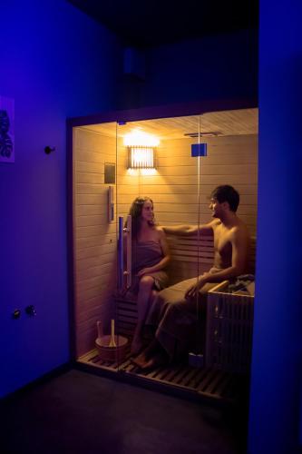 a man and a woman sitting in a sauna at Hotel Garnì San Giorgio in Trento