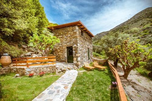 a stone building with a bench and a house at Ellafos Traditional Living in Elafonisi
