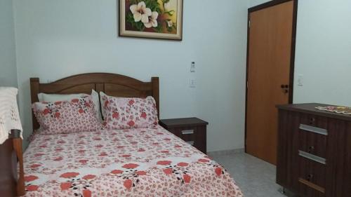 a bedroom with a bed and a dresser with a bedspread at Casa de temporada em Aruanã in Aruanã