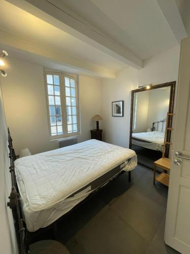 a bedroom with a large bed and a mirror at Basil - Vue imprenable sur la Basilique in Saint-Maximin-la-Sainte-Baume