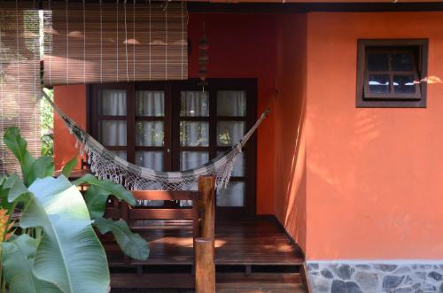 a porch with a hammock in front of a house at Vila Sofia chalès in Morro de São Paulo