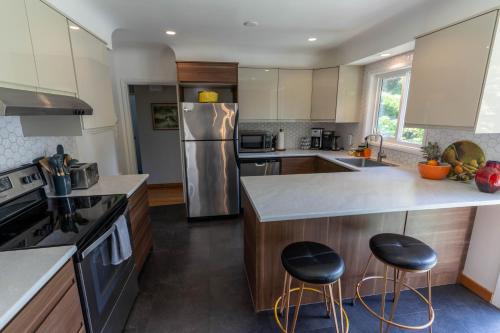 a kitchen with stainless steel appliances and wooden cabinets at Mid-Century Modern Apartment at Horner Park in Victoria