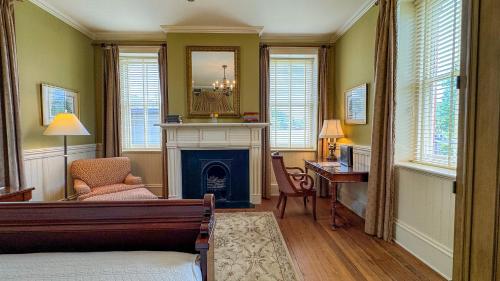 a bedroom with a fireplace and a desk with a mirror at Wentworth Mansion in Charleston