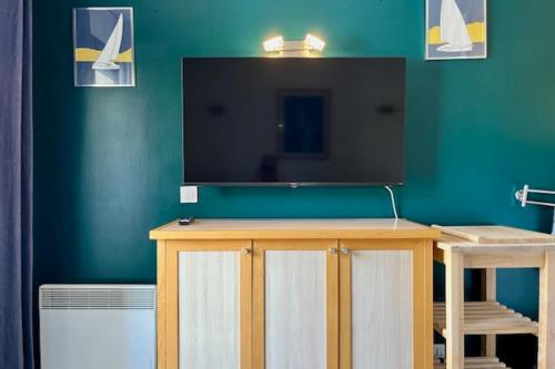 un salon avec une télévision sur un mur végétal dans l'établissement Charming accommodation with pool in La Rochelle, à La Rochelle