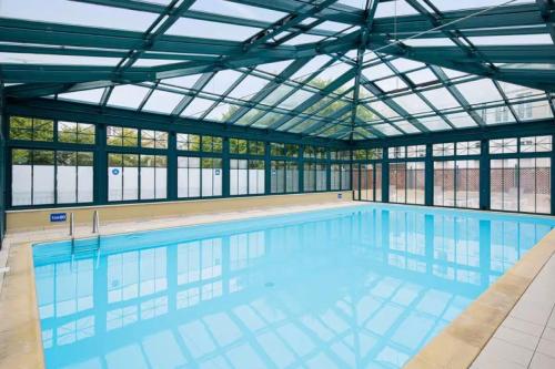 une grande piscine avec un plafond de verre dans l'établissement Charming accommodation with pool in La Rochelle, à La Rochelle