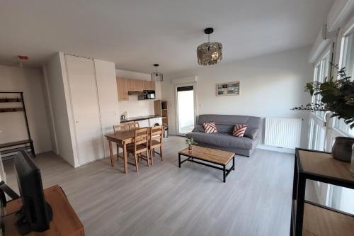 un salon avec un canapé et une table dans l'établissement Charming 45m in Aytré - near La Rochelle, à Aytré
