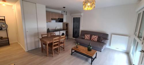 un salon avec un canapé et une table dans l'établissement Charming 45m in Aytré - near La Rochelle, à Aytré