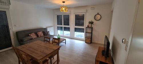 un salon avec un canapé et une table dans l'établissement Charming 45m in Aytré - near La Rochelle, à Aytré