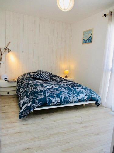 une chambre avec un lit avec une couette bleue et blanche dans l'établissement Bright and well decorated nest in La Rochelle, à La Rochelle