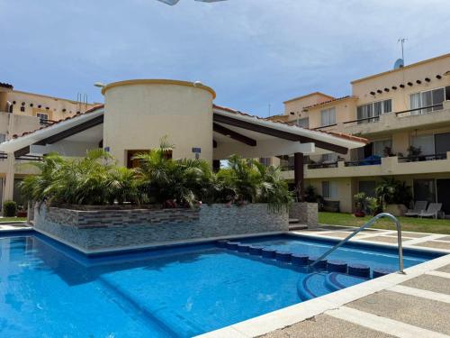 a swimming pool in front of a building at Suite Villas Palmas Diamante in Acapulco