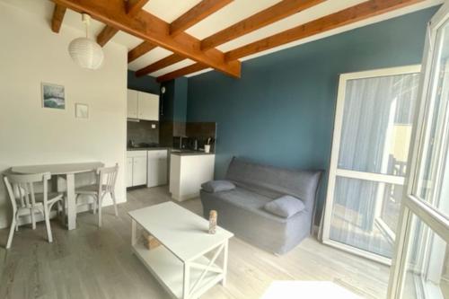 un salon avec un canapé et une table dans l'établissement CHARMANT Duplex 36 m avec Balcon proche de la MER, à La Rochelle
