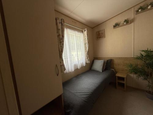 a small room with a bed and a window at Forest beach Shorefield Park in Lymington
