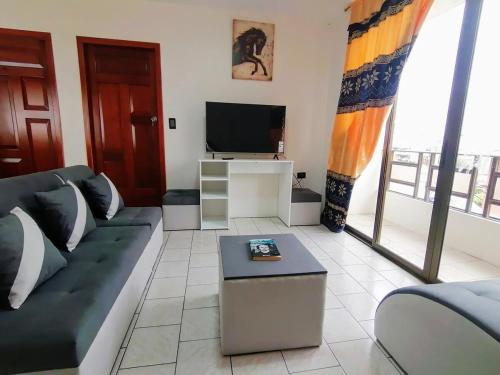 a living room with a couch and a tv at Departamento 28 in Piñas