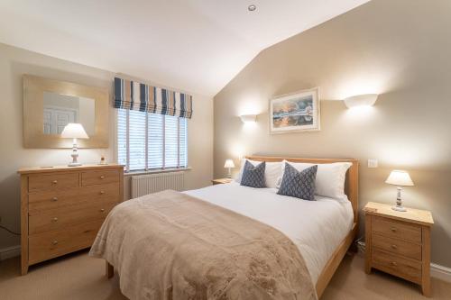 una camera da letto con un letto con due comodini e una finestra di Yew Tree Cottage a Bowland Bridge