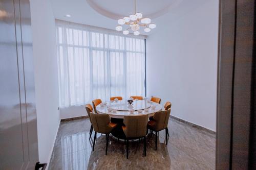 a dining room table with chairs and a chandelier at 凯丽酒店Kiri Hotel at Kigali Rwanda in Kigali