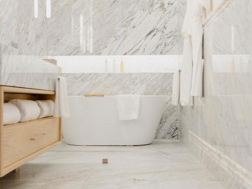 a white bathroom with a large tub in the corner at Hotel Maria Camille in San Miguel de Allende