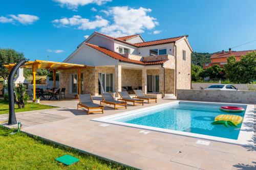 a villa with a swimming pool and a house at Holiday Home Bodula in Mrljane