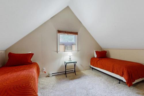 a attic room with two beds and a window at The Birch Chalet in Newland