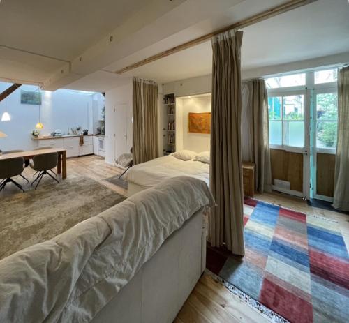 une chambre avec un lit et un bureau dans une pièce dans l'établissement Chambres Studio Eleusis-Paris, à Paris