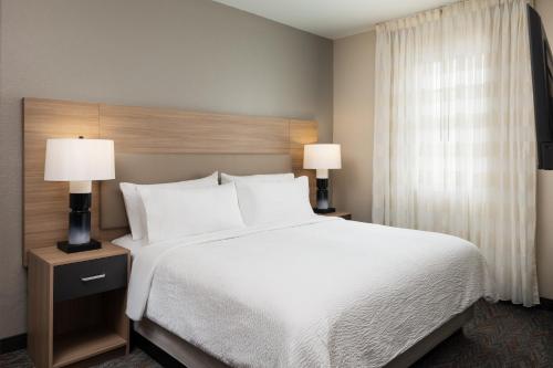 a bedroom with a large bed and two lamps at Candlewood Suites Miami - Doral by IHG in Tamiami