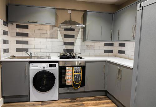 a kitchen with a washer and dryer in it at Stylish Flat in Wolverhampton - Short and long Stay with Free Parking in Wolverhampton