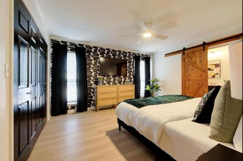 Un dormitorio con una cama grande y un televisor. en Ultimate Game Night Getaway Hot Tub, Arcade & Fun, en Oklahoma City
