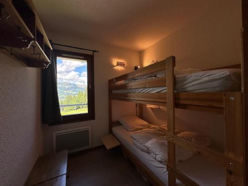une chambre avec deux lits superposés et une fenêtre dans l'établissement Appartement cosy 6 pers, cuisine équipée, balcon, casier à skis - Morillon 1100 - FR-1-642-15, à Morillon