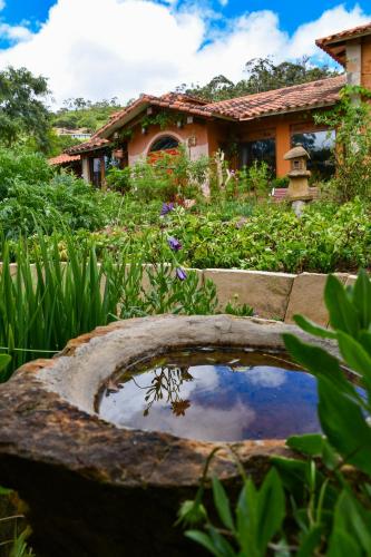a house with a garden with a pond in the yard at Casa Samai Boutique in Samaipata