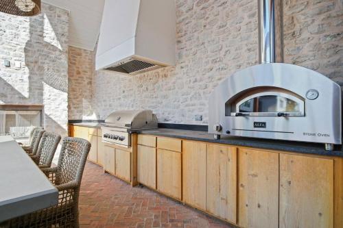 a kitchen with a stove and a counter with chairs at Onyxthelark Designer Edmond Oasis in Edmond