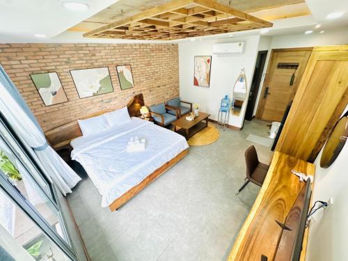 a bedroom with a bed and a brick wall at 205MSNK Spacious Studio l Window & Kitchen in Can Tho