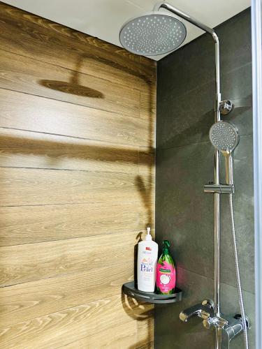 a bathroom with a shower with two bottles on a shelf at 205MSNK Spacious Studio l Window & Kitchen in Can Tho