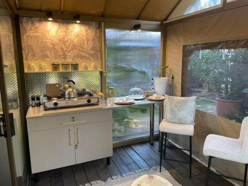 a kitchen with a stove and a table in a caravan at African Paradise - Garden Glamping - Outdoor Shower in Benoni