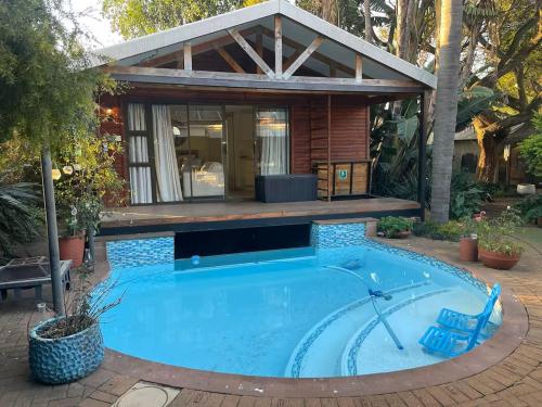 a house with a swimming pool in front of a house at African Paradise - Garden Glamping - Outdoor Shower in Benoni