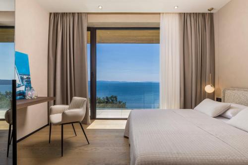 a bedroom with a bed and a large window at Opatija Luxury Villa Ella in Mošćenička Draga