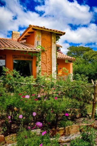 an orange house with flowers in front of it at Casa Samai Boutique in Samaipata