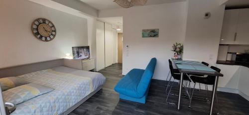 - une chambre avec un lit, une table et une horloge dans l'établissement Appartement studio O fil de l'O à 12 kilomètres de Disneyland Paris, à Crécy-la-Chapelle