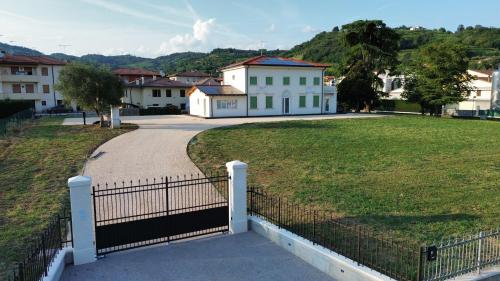a fence in front of a park with houses at Soggiorno in villa - apt with kitchen and terrace in Gambellara