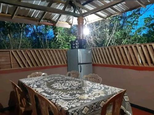 a table with chairs and a refrigerator on a balcony at Mk yala safari and guest house in Hambantota